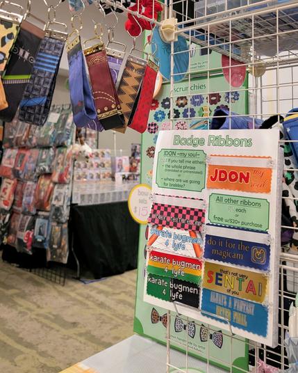 a view from the inside of the pocket toku booth, featuring key fobs and badge ribbons