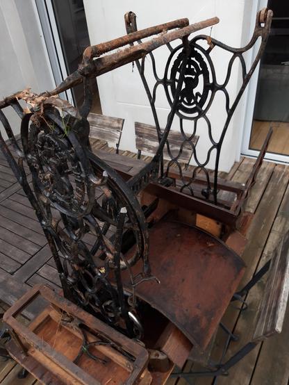 Photo d'une vielle machine à coudre à pédale posée à l'envers sur une table