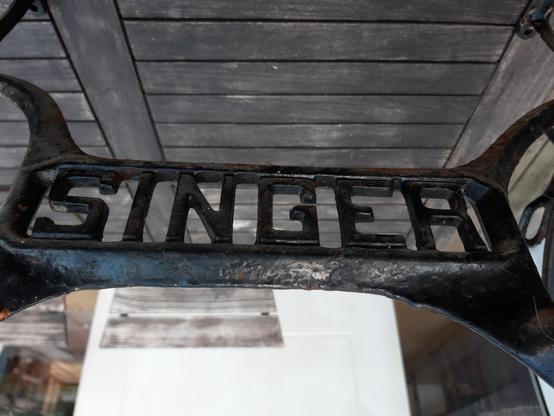 Photo du logo Singer sur le cadre d'une machine à coudre