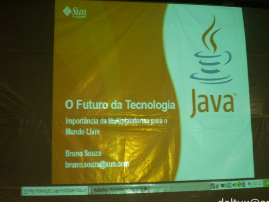 Projeção da tela inicial de uma apresentação com o título "O futuro da tecnologia: importância da multiplataforma para o mundo livre". Bruno Souza, bruno.souza@sun.com e com um grande logotipo de xícara de café estilizada da plataforma Java, bem como, num canto, Sun Microsystems.