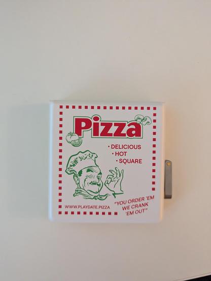 Playdate console with in case that looks like a pizza box.