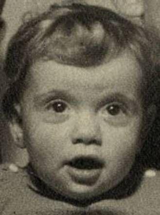 A photo of a young girl with large eyes and opened mouth.