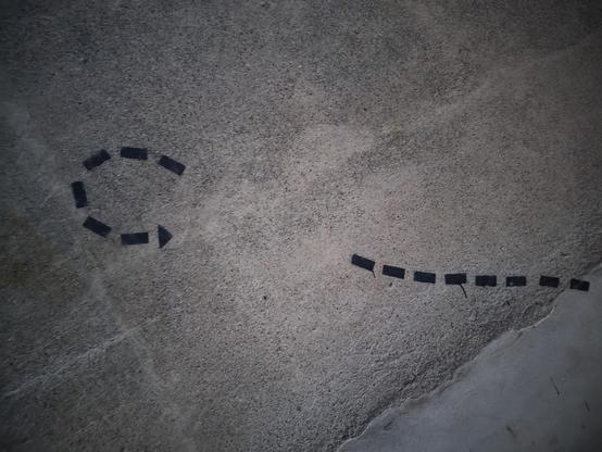 Photo de graffiti représentant une ligne de traits en pointillés séparés d'autres pointillés formant un U avec une flèche au bout, en demi-tour.