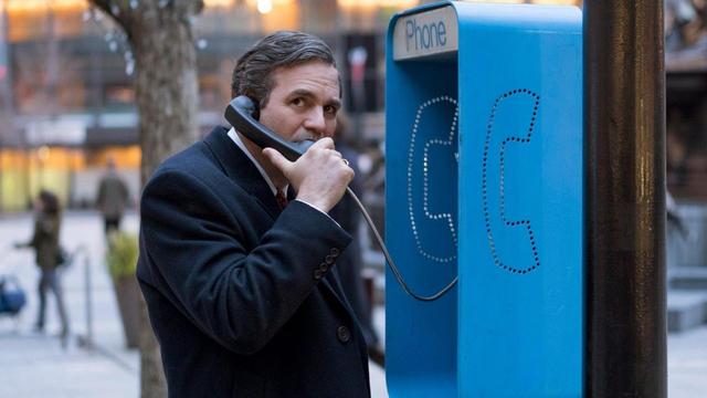 Ein Mann (Mark Ruffalo) in einem dunklen Mantel telefoniert an einer blauen Telefonzelle mit der Aufschrift 'Phone' in einer urbanen Umgebung. (Bild: HR/ARD Degeto/2019 Focus Features LLC and Storyteller Distribution Co., LLC.)