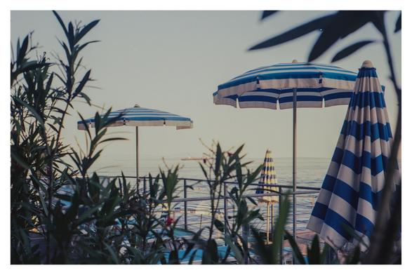Color photograph of a few blue and white parasols on the Franz Josef Promenade on the way from Opatija to Volosko. The photo is slightly overexposed—a problem I had with many photos during this vacation.