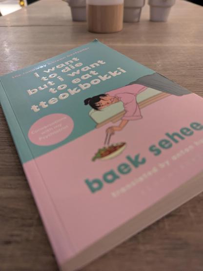 Green and pink book cover will line illustration of a woman reaching towards a bowl of food with chop sticks.