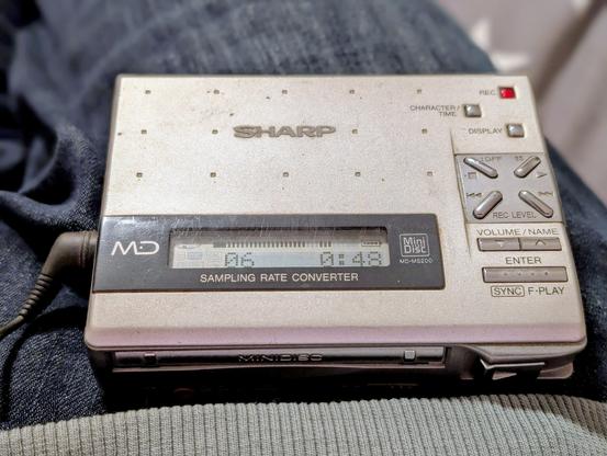 Ein silberner Minidisc-Player. Sieht aus eie ein Walkman nur ohne Kassette.
