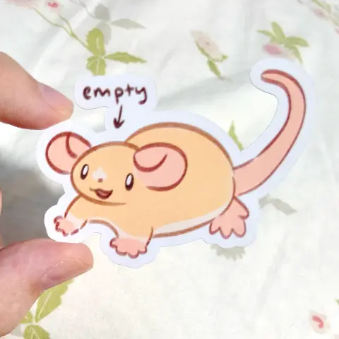 a sticker of my rat OC Star. he's not wearing his iconic goggles. instead, he's just staring blankly into space, smiling. an arrow points at his head and says, "empty"