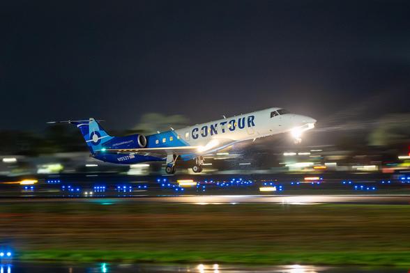 Contour Airlines Embraer ERJ-135 on climbout from the Santa Barbara Airport at night, in the rain.