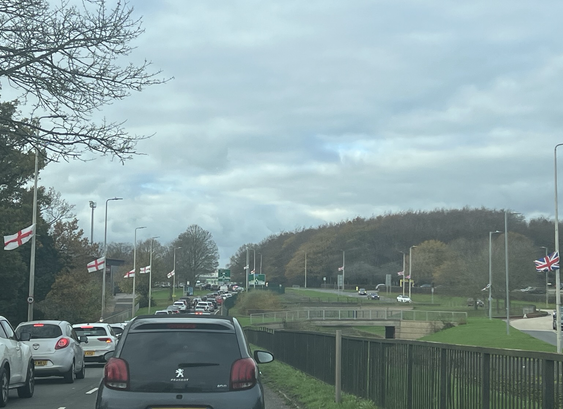 St Georges flags on lamposts outside Stevenage football ground entrance on both sides of a dual carriageway