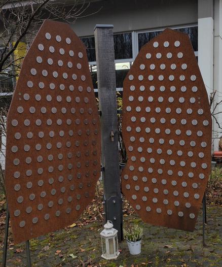 Foto:
A. Dietrich, Lehrer an der Schule, gestaltete dieses Denkmal nach dem Vorbild der Lunge eines Menschen.
Die Lungenbläschen tragen die Namen der Verstorbenen.

Zu dem Holzkreuz in der Bildmitte:
Ein ehem. deutscher Gefangener schnitzte dieses während der sowj. Kriegsgefangenschaft.
Er stiftete es zur Erinnerung an die sowj. Opfer, die in seiner späteren Heimatstadt Lüdenscheid starben.