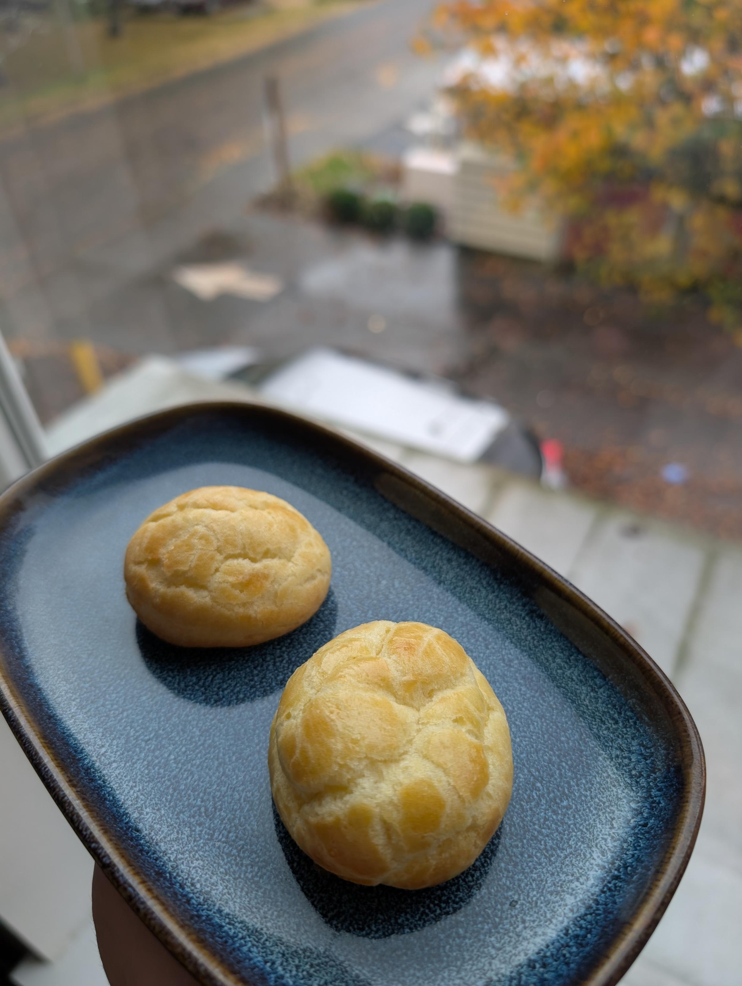 Two unfilled choux pastries next to the window