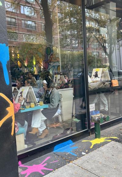 West side Manhattan Paint and Pour, closer view from the street. People seated, painting.