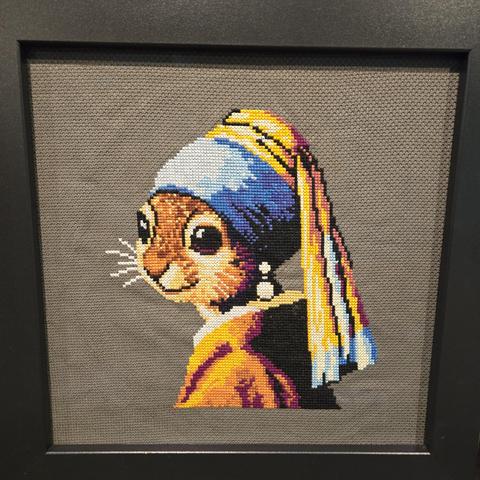 A cross stitch of Vermeer's Girl with a Pearl Earring, but the girl is a squirrel.