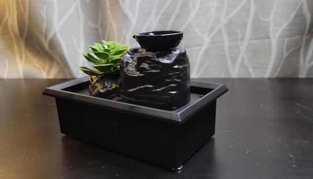 A cheap-looking plastic fountain. It has a very fake-looking plastic succulent growing out of it.