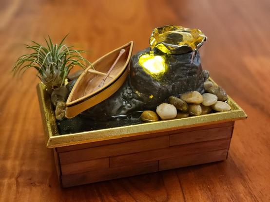 The fountain, again, but the canoe is turned right-side up, with the paddle sitting against the thwart.