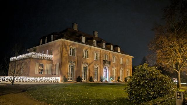Ein hell erleuchtetes, mehrstöckiges Gebäude in der Nacht. Das Gebäude ist rechteckig und hat mehrere Fenster in regelmäßigen Abständen. Die Fenster sind mit Vorhängen bedeckt. Das Gebäude hat ein braunes Dach und eine Reihe von Kaminen. Vor dem Gebäude erstreckt sich ein Rasen. Im Vordergrund befindet sich ein buschiger Baum, rechts von dem Gebäude.

Bereitgestellt von @altbot, privat und lokal generiert mit Gemma3:27b