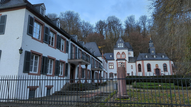 Schloss Dagstuhl, the Leibniz Institute residential location for computer science workshops. A white monastery-like building with a wooded ridge behind.