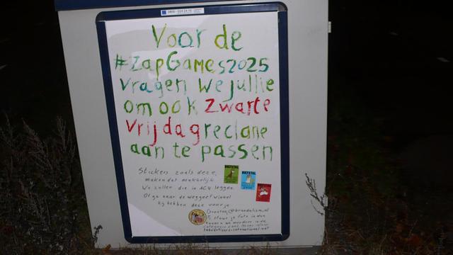 straatkastje by night
witte poster met groene en rode letters en 4 stickers, zie caption