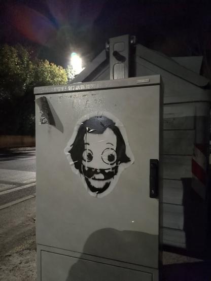 Pasteup su casottino elettricità con una caricatura di Jack Nicholson, logo di guerrilla stickers.