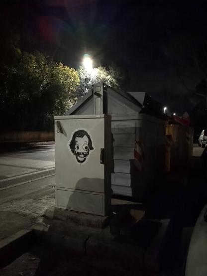 Pasteup su casottino elettricità con una caricatura di Jack Nicholson, logo di guerrilla stickers.