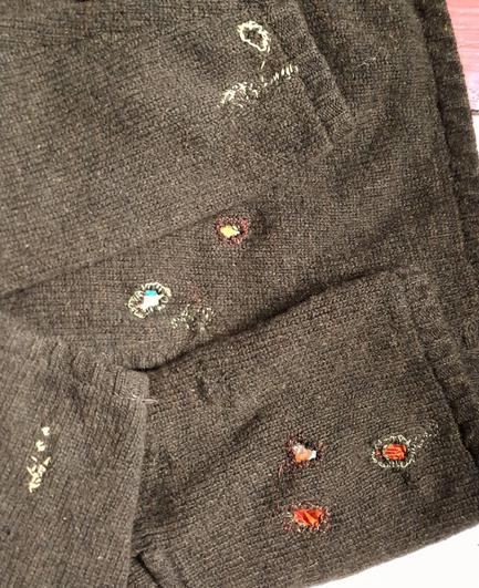 Part of another repaired sweater. The biggest holes are backed with silk in contrast colours, wild embroidery secures the edges.