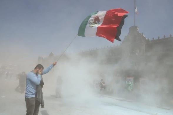 Manifestantes con bandera de Mexico frente a Palacio Nacional