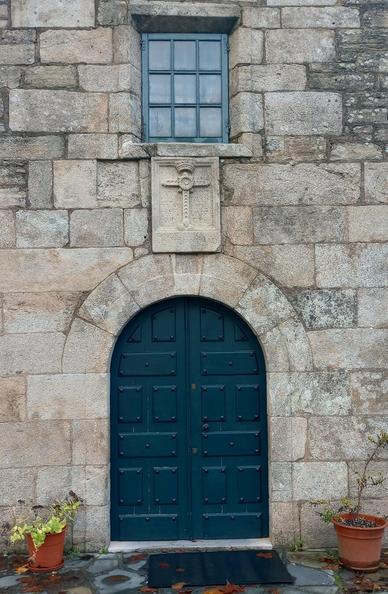 Stone church façade with an arched double door. Above is a small window and a stone relief of a cross. Potted plants flank the entrance.
#portas #doors #laureanoaraujo #santiagodecompostela #galiza
Santiago de Compostela, 17 de novembro de 2025