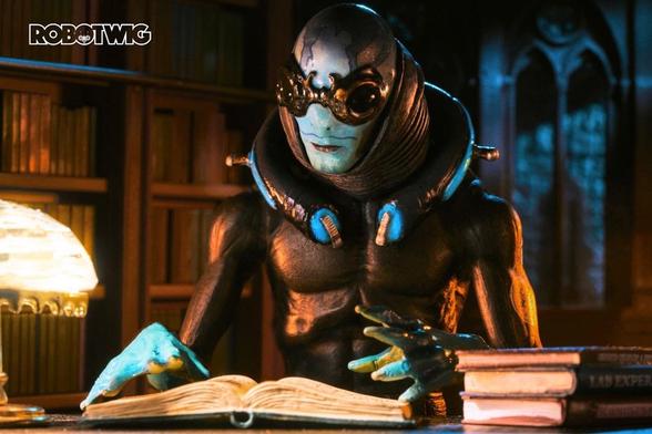 Abe Sapien sits in a library doing research