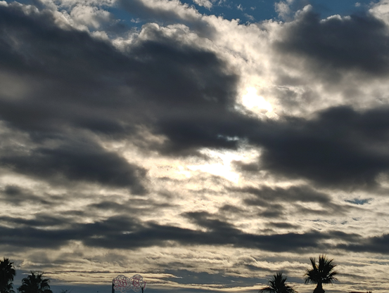 dark cloudy sky with morning sun glowing through them