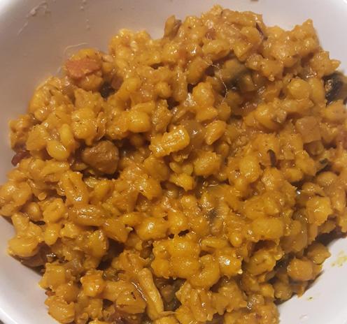 Spicy bacon and mushroom orzotto, served in a white bowl