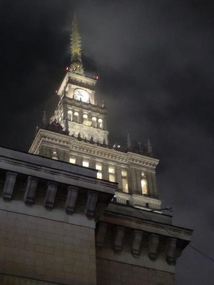 Top part of the socrealistic skyscraper, with white clockface and spire