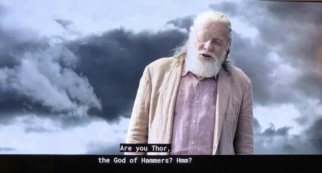 Anthony Hopkins as Odin dressed in a simple human pastel linen suit. He asks Thor, Are you Thor the God of Hammers? Dark clouds behind him
