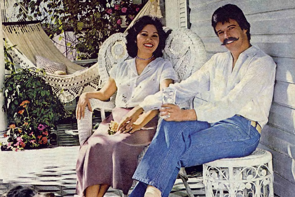 1980 Leisurely Moments on a Sunlit Porch

The image captures an idyllic moment of leisure, with two individuals seated comfortably on a porch.
They are sharing a relaxed and joyful time together, as indicated by their smiles and casual poses.