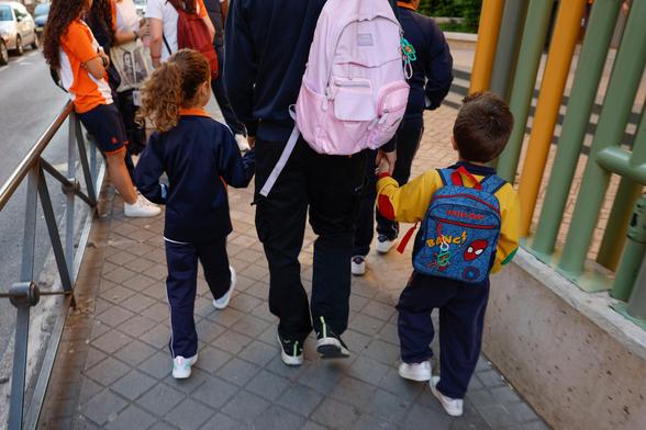 Un padre acerca a sus hijos al colegio, en abril de 2025, en Madrid.