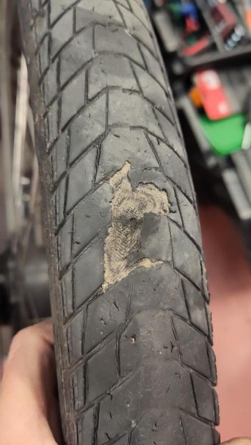 Roue de vélo avec la gomme du pneu tellement usée qu'il roule sur la carcasse