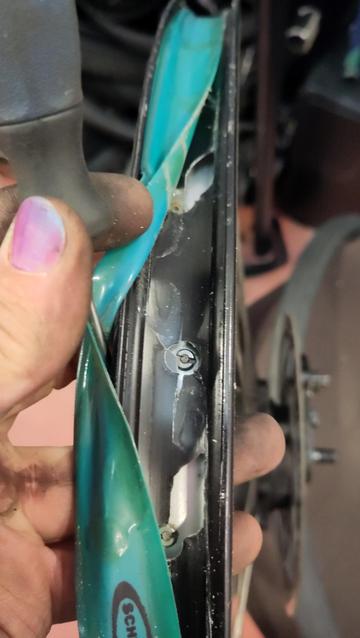 Même roue que la photo précédente, le fond de jante est écarté pour laisser apparaître des trous dans la jante dont la paroi en alu est cassée