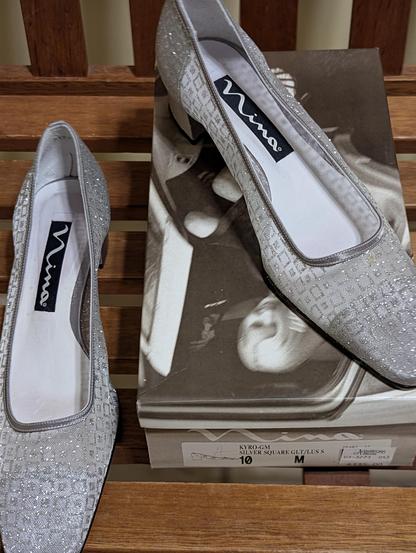 A pair of sparkly shoes suitable for partying sits on a shoe box on a bench.