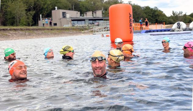 A group of swimmers in Lisvane and Llanishen Reservoir, Cardiff, with clear water and surrounding greenery, reflecting its new ‘excellent’ bathing water status.