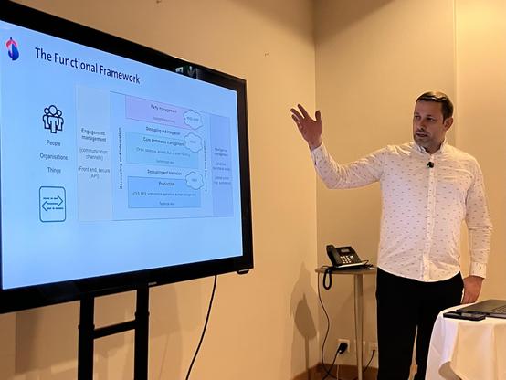 A speaker points to a software architecture slide