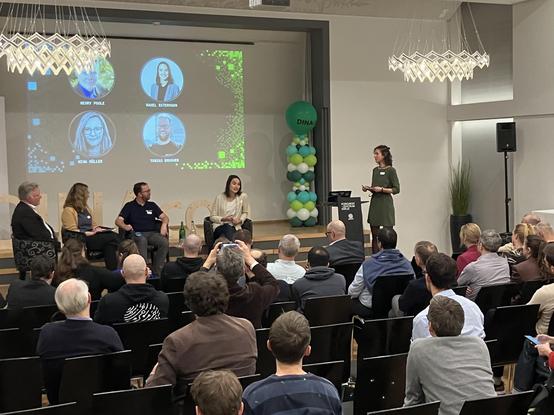 A panel and moderator in front of an audience.

HENRY POOLE
RAHEL ESTERMANN
NINA MÜLLER
TOBIAS BRUNNER