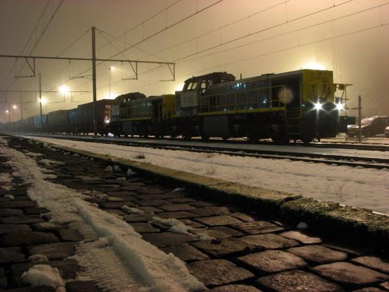Deux locomotives diesel en tête d'un train de containers à Arlon dans un environnement brumeux et neigeux.

Two diesel locomotives heading a container freight train in Arlon in a foggy and snowy environment.