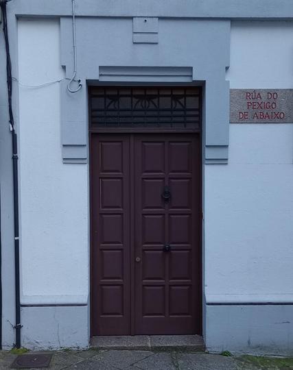 A closed dark double door with decorative geometric panels is set in a white wall. To the right, a red street sign reads "Rúa do Pexigo de Abaixo".
#portas #doors #laureanoaraujo #santiagodecompostela #galiza
Santiago de Compostela, 18 de novembro de 2025
