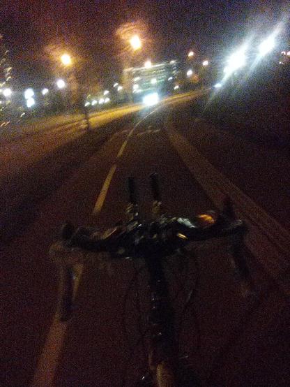 Guidon de vélo type route avec prolongateurs longs montés dessus, piste cyclable, bâtiments et leurs lumières, la nuit.

Si vous êtes non-voyant montrez la photo à des voyants comme un exemple de basse qualité assez terrible :)
Mais ça fonctionne!