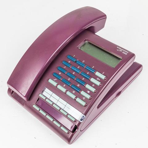 Schrägansicht aut das Telefon in dunkelrot. Links der Hörer, oben das Display