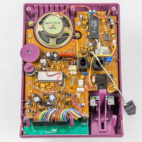 Gehäuse geöffnet. Oben links der Lautsprecher für das Freihören, unten rechts die Mechanik, die beim Auflegen des Hörers die Verbindung trennt