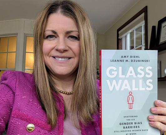 Amy Diehl holding a paperback copy of GLASS WALLS