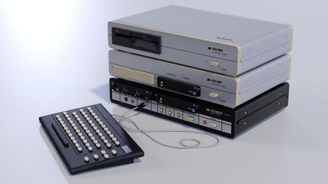 A photorealistic rendering of the KC 85/3 computer with keyboard, floppy controller and floppy drive on a white background.