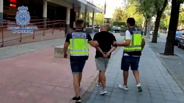 Dos policías trasladan a un detenido.