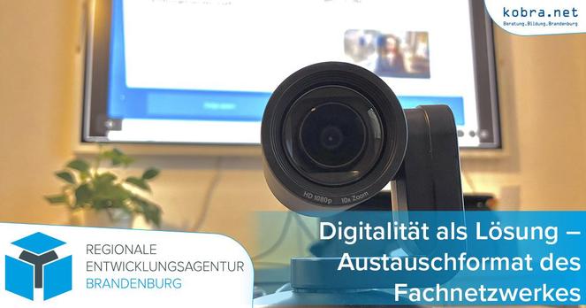 Eine Webcam steht auf einem Tisch vor einem Smartboard.